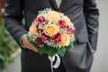 Beautiful bright wedding bouquet of the bride in the hands of the groom Royalty Free Stock Photo