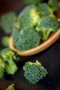 Beautiful broccoli florets on a wooden plate on a slate board. Royalty Free Stock Photo