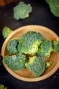 Beautiful broccoli florets on a wooden plate on a slate board. Royalty Free Stock Photo