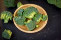 Beautiful broccoli florets on a wooden plate on a slate board. Royalty Free Stock Photo