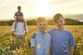 Beautiful brother boy in daisy field on sunset with father on the back Royalty Free Stock Photo