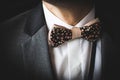 Beautiful brown bow tie with small colorful flowers on white shirt and grey jacket Royalty Free Stock Photo