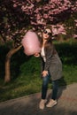 Beautiful brown hair model hold a cotton candy in hands and give a kiss. Young woman with pink cotton candy Royalty Free Stock Photo