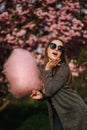 Beautiful brown hair model hold a cotton candy in hands and give a kiss. Young woman with pink cotton candy Royalty Free Stock Photo