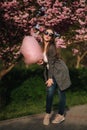 Beautiful brown hair model hold a cotton candy in hands and give a kiss. Young woman with pink cotton candy Royalty Free Stock Photo