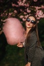 Beautiful brown hair model hold a cotton candy in hands and give a kiss. Young woman with pink cotton candy Royalty Free Stock Photo