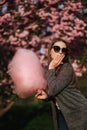 Beautiful brown hair model hold a cotton candy in hands and give a kiss. Young woman with pink cotton candy Royalty Free Stock Photo