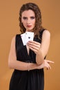 Beautiful brown-haired woman holding two aces as a sign for poker game, gambling and casino Royalty Free Stock Photo