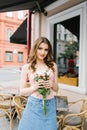 Beautiful brown-haired young girl with a bouquet of roses, professional makeup and styling Royalty Free Stock Photo