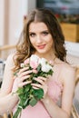 Beautiful brown-haired young girl with a bouquet of roses, professional makeup and styling. Romantic and gentle image. Royalty Free Stock Photo