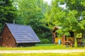 Beautiful brown wooden huts and wooden benches in the forest