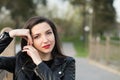 Beautiful brunette in a black jacket and red lips close-up. Closeup of street style fashion Portrait of a beautiful girl in autumn Royalty Free Stock Photo