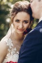 Beautiful brunette bride portrait face close-up, sensual groom kissing hugging bride, newlywed couple posing outdoors in park Royalty Free Stock Photo