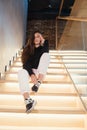 Young beautiful brunette fashion model posing on stairs. Royalty Free Stock Photo