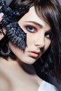 Beautiful brunette girl with big blue eyes holding a black brooch decoration in the form of birds. Fashion portrait natural makeup Royalty Free Stock Photo