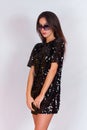 Beautiful brunette girl in a black dress and sunglasses. Brunette with long black hair Royalty Free Stock Photo