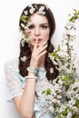 Beautiful brunette girl in blue dress with a gentle romantic make-up, pink lips and flowers. The beauty of the face. Royalty Free Stock Photo