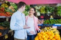 Beautiful brunette girl and boyfriend buying citruses Royalty Free Stock Photo