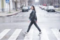 Beautiful brunette girl crosses the road on a pedestrian crossing. Royalty Free Stock Photo