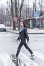Beautiful brunette girl crosses the road on a pedestrian crossing. Royalty Free Stock Photo