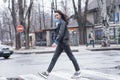 Beautiful brunette girl crosses the road on a pedestrian crossing. Royalty Free Stock Photo