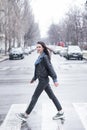 Beautiful brunette girl crosses the road on a pedestrian crossing. Royalty Free Stock Photo