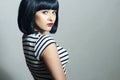Beautiful Brunette Girl in Dress. Black Hair. bob Haircut. Red Lips. Beauty Woman with Fringe Royalty Free Stock Photo