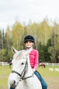 A sweet girl riding a white horse, an athlete engaged in equestrian sports, a girl hugs and kisses a horse. Royalty Free Stock Photo