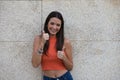 Beautiful brunette girl with long hair is happy and shows both hands with thumbs up because everything is correct and ok, isolated Royalty Free Stock Photo