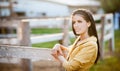 Beautiful brunette girl with long hair smiling near an old wooden fence. Royalty Free Stock Photo