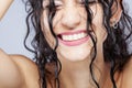 Beautiful brunette girl with long wet hair, closeup studio portrait. Very happy smiling expression