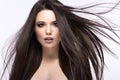 Beautiful brunette girl in move with a perfectly smooth hair, and classic make-up. Beauty face. Royalty Free Stock Photo