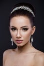 Beautiful brunette girl with perfect skin, evening make-up, wedding hairstyle and accessories. Beauty face.