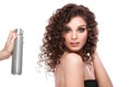 Beautiful brunette girl with a perfectly curly hair with spray bottle, and classic make-up. Beauty face. Royalty Free Stock Photo