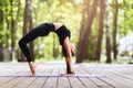 Beautiful brunette girl practicing yoga on nature, performs a gymnastic exercise bridge Royalty Free Stock Photo