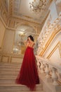 Beautiful girl in a red ball gown in palace interiors Royalty Free Stock Photo