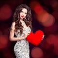 Beautiful brunette girl with red heart gift for Valentines Day. Royalty Free Stock Photo