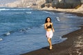 Beautiful brunette girl running in the beach at summer vacations Royalty Free Stock Photo