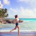 Beautiful brunette girl running in Caribbean beach Royalty Free Stock Photo