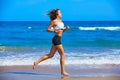 Beautiful brunette girl running in a summer beach Royalty Free Stock Photo