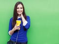 Beautiful brunette girl standing with a glass in his hand near the green wall and smiling at the camera Royalty Free Stock Photo