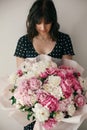 Beautiful brunette girl in vintage dress holding big bouquet with pink and white peonies. Happy stylish woman with peony flowers Royalty Free Stock Photo