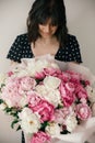 Beautiful brunette girl in vintage dress holding big bouquet with pink and white peonies. Happy stylish woman with peony flowers Royalty Free Stock Photo