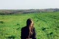 Beautiful brunette girl in windy green field, sunny springtime, Royalty Free Stock Photo