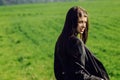 Beautiful brunette girl in windy green field, sunny springtime, Royalty Free Stock Photo