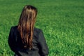 Beautiful brunette girl in windy green field, sunny springtime, Royalty Free Stock Photo