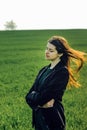 Beautiful brunette girl in windy green field, sunny springtime, Royalty Free Stock Photo