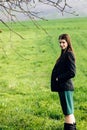 Beautiful brunette girl in windy green field, sunny springtime, Royalty Free Stock Photo