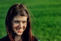 Beautiful brunette girl in windy green field, sunny springtime, Royalty Free Stock Photo