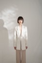 Beautiful brunette with graphic bob haircut wear beige fashion pantsuit